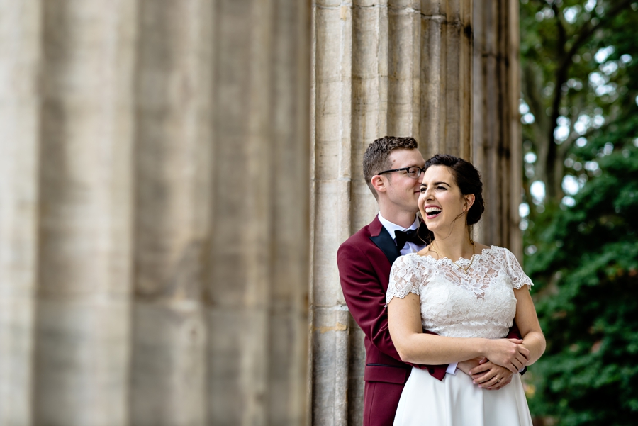 A man holds his new wife on the steps of the first bank of America after their Philadelphia Wedding.